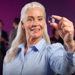 donna che tiene tra le dita un apparecchio acustico digitale di ultima generazione
